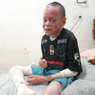 Gabriel sentado na cama